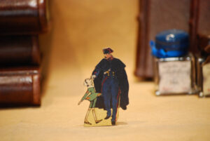 Pinocchio mit Carabiniere, flachschnittige Holzfigur aus der Reihe 'Die Abenteuer des Pinocchio'.