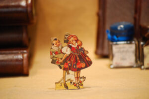 Pinocchio mit Mädchen, flachschnittige Holzfigur aus der Reihe 'Die Abenteuer des Pinocchio'